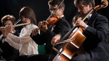 Leden van een orkest spelen op hun instrumenten: een cello, viool en fluit op een rij met een donkere achtergrond