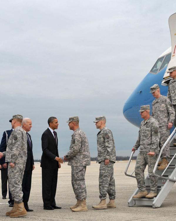 De Amerikaanse president Barack Obama en vicepresident Joe Biden schudden de hand met Amerikaanse militairen die uit een vliegtuig stappen en terugkomen uit Irak.