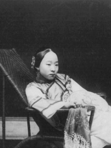 Een zwart-witfoto van een Chinese vrouw die op een ligstoel ligt